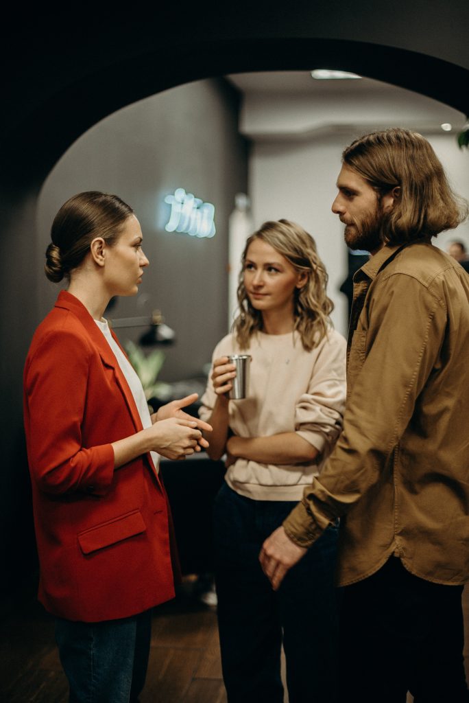 Three people talking in a modern indoor setting.