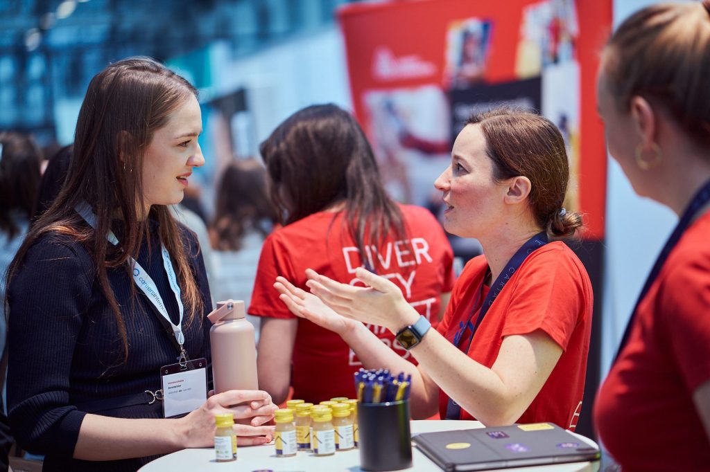Two women talking at a career event booth