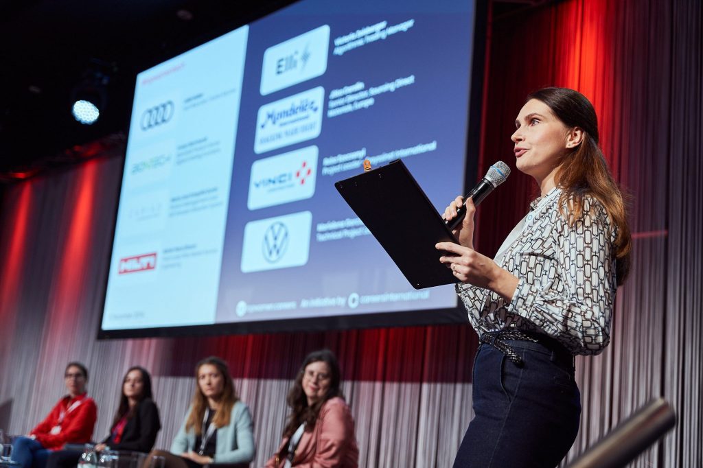 Woman moderating a panel discussion at a tech career event