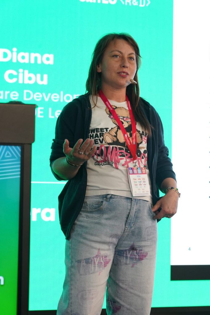 Woman wearing a conference badge and headset microphone presenting on stage in front of a green Criteo R&D screen.